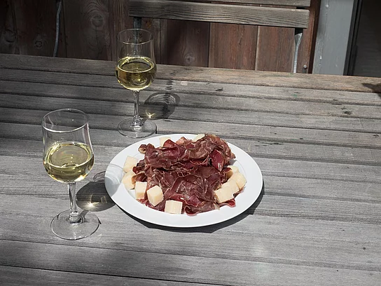Schinkenteller und zwei Gläser Weiswein